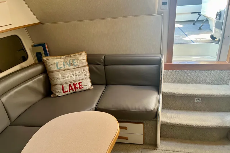 Slide: The Image of Interior of 1994 Sea Ray 370 Express Cruiser with cozy seating and decorative pillow. - 23