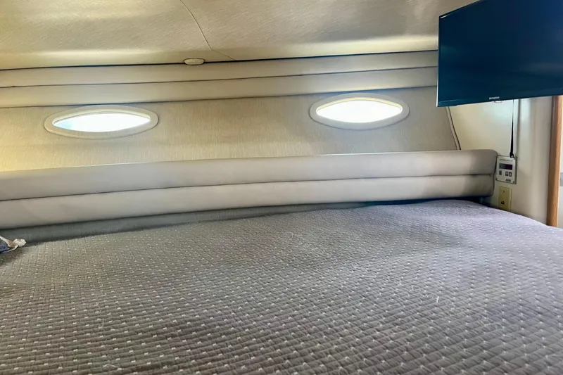 Slide: The Image of Interior cabin of 1994 Sea Ray 370 Express Cruiser with bed and porthole windows. - 25