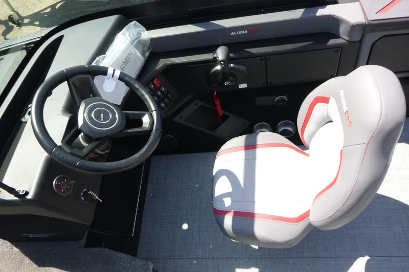 Slide: The Image of 2025 Alumacraft Trophy 185X Sport boat cockpit with steering wheel and cushioned seat. - 11