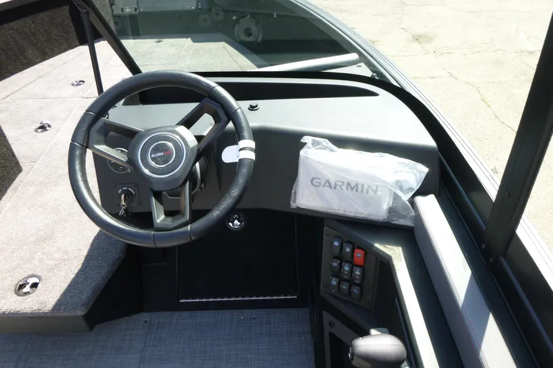 Slide: The Image of 2025 Alumacraft Trophy 185X Sport dashboard with steering wheel and Garmin device. - 12
