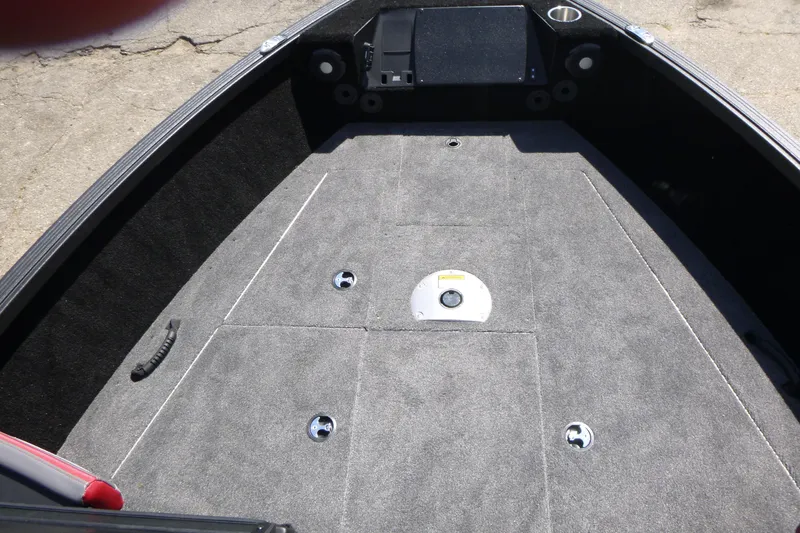 Slide: The Image of 2025 Alumacraft Trophy 185X Sport boat interior with carpeted deck and storage compartments. - 7