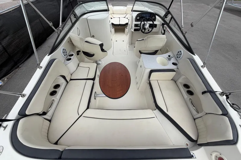 Slide: The Image of 2023 Stingray 231 DC boat interior with seating, table, and steering console. - 14