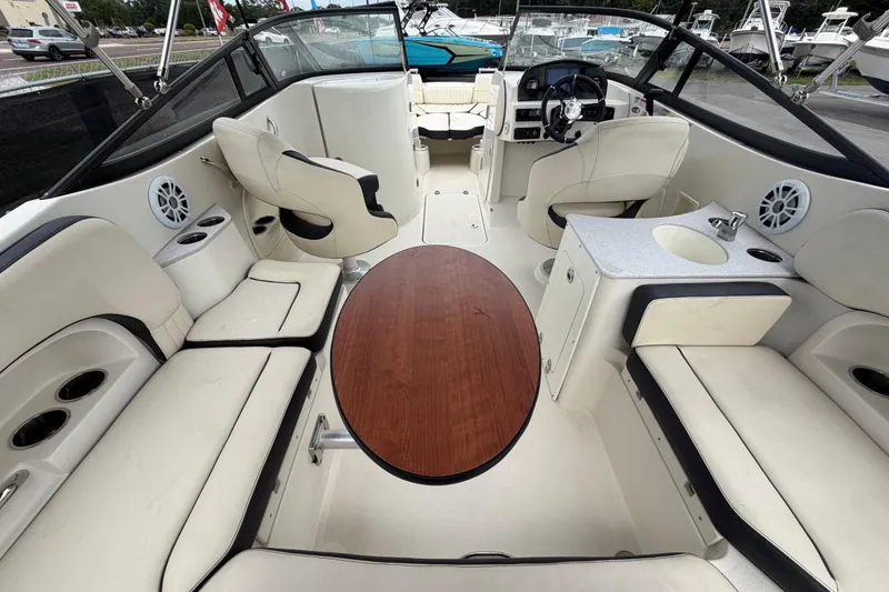 Slide: The Image of 2023 Stingray 231 DC boat interior with seating, table, and helm. - 15