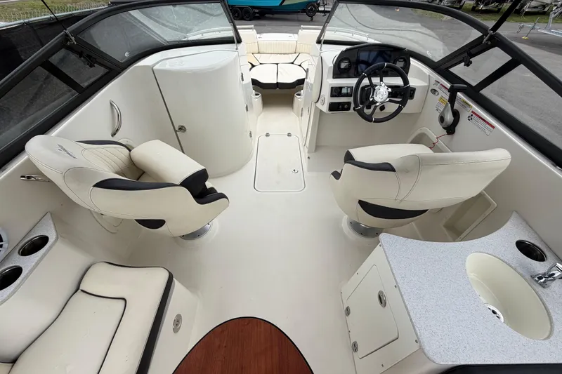 Slide: The Image of 2023 Stingray 231 DC boat interior with steering wheel, seating, and sink. - 16