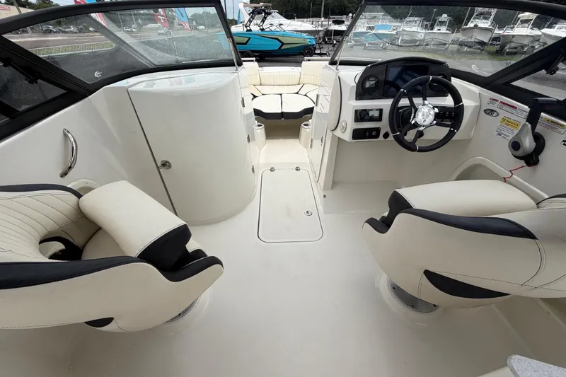 Slide: The Image of 2023 Stingray 231 DC boat interior with steering wheel and seating arrangement. - 19