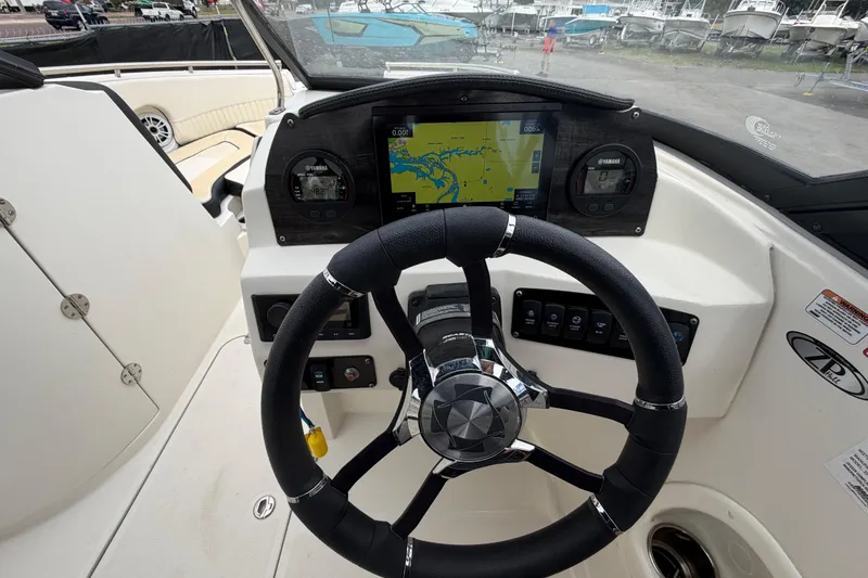 Slide: The Image of 2023 Stingray 231 DC boat dashboard with steering wheel and navigation display. - 21