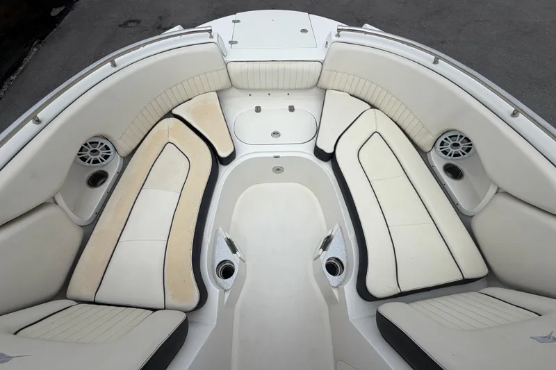 Slide: The Image of 2023 Stingray 231 DC boat interior with white cushioned seating and built-in speakers. - 33