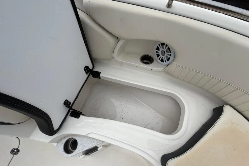 Slide: The Image of 2023 Stingray 231 DC boat interior storage compartment with speaker and cup holder. - 35