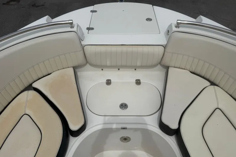 Slide: The Image of 2023 Stingray 231 DC boat interior with white cushioned seating and storage compartment. - 38