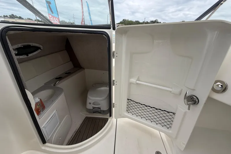 Slide: The Image of 2023 Stingray 231 DC boat interior with compact bathroom and toilet. - 48
