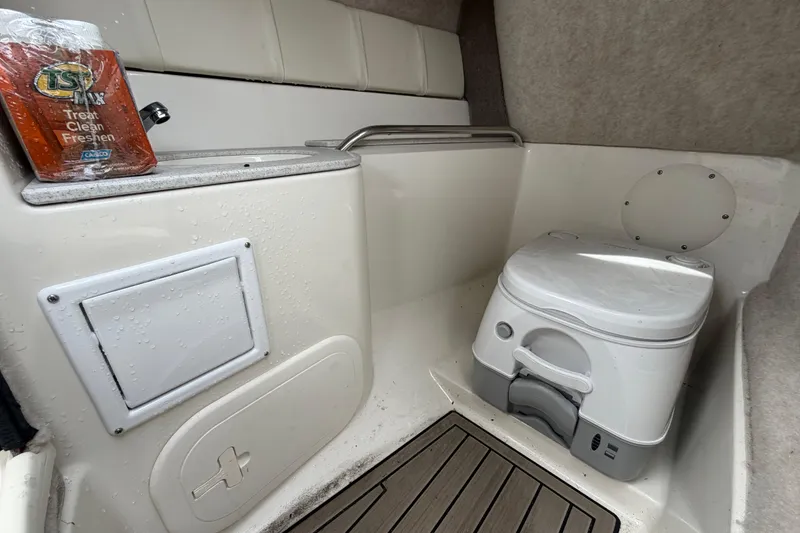 Slide: The Image of 2023 Stingray 231 DC boat interior with portable toilet and cleaning supplies. - 51