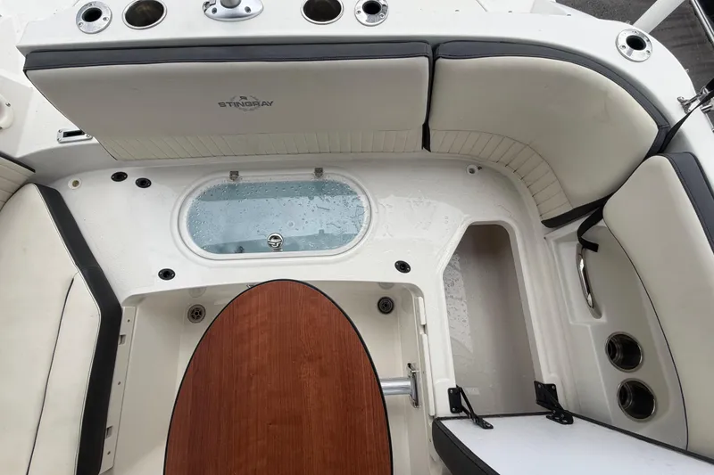 Slide: The Image of 2023 Stingray 231 DC boat interior with seating and storage compartments. - 56