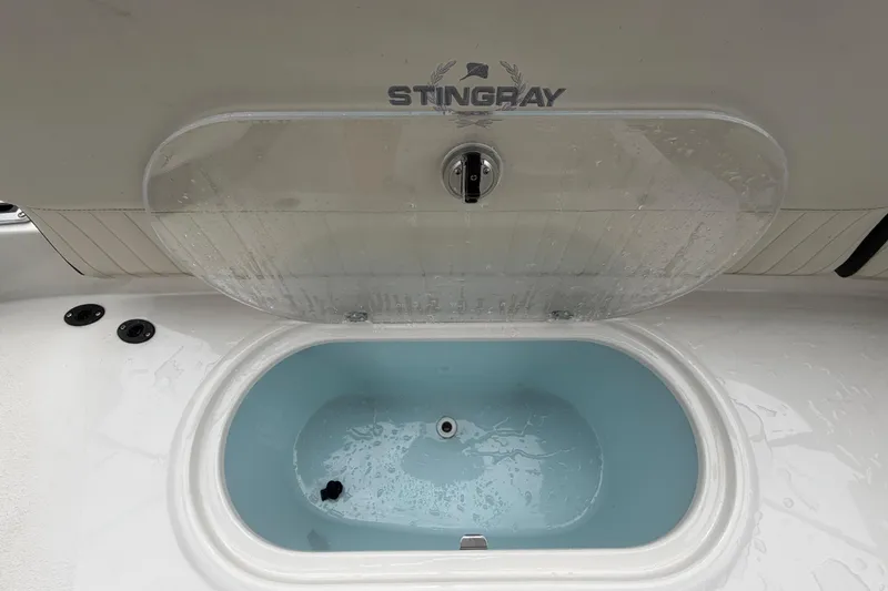 Slide: The Image of Livewell compartment on a 2023 Stingray 231 DC boat, featuring a transparent lid. - 57