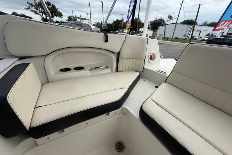 Slide: The Image of 2023 Stingray 231 DC boat interior with cushioned seating and storage compartments. - 58