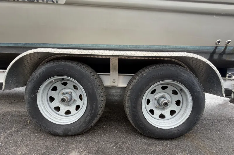 Slide: The Image of Trailer wheels of a 2023 Stingray 231 DC boat on asphalt surface. - 71