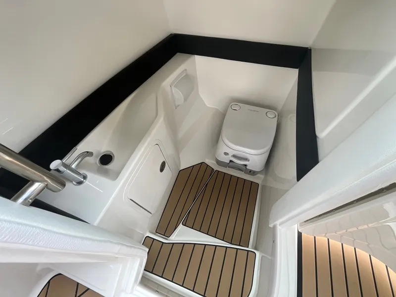 Slide: The Image of The image shows a compact boat toilet with a modern white design and wooden flooring. - 33