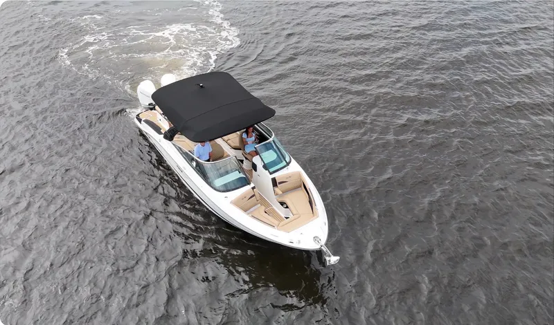 Slide: The Image of A sleek 2027 Sea Ray SLX 280 Outboard boat cruising on calm water with a black sunshade. - 11
