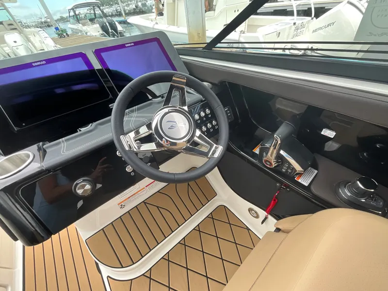 Slide: The Image of The image shows the cockpit of a Sea Ray SLX 280 Outboard with a modern steering wheel and two screens. - 23