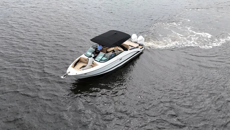 Slide: The Image of A 2027 Sea Ray SLX 280 Outboard cruising on calm water. It features a black canopy. - 7