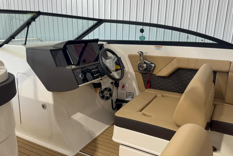 Slide: The Image of 2023 Sea Ray SDX 290 boat interior with modern helm and beige seating. - 2