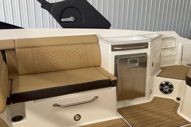 Slide: The Image of 2023 Sea Ray SDX 290 interior with tan seating, stainless steel fridge, and teak flooring. - 6
