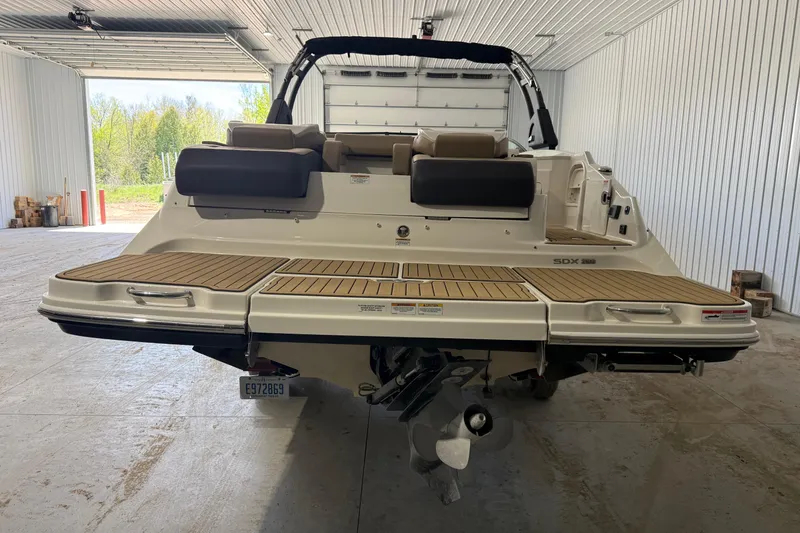 Slide: The Image of 2023 Sea Ray SDX 290 boat in a garage, showcasing rear deck and seating. - 7
