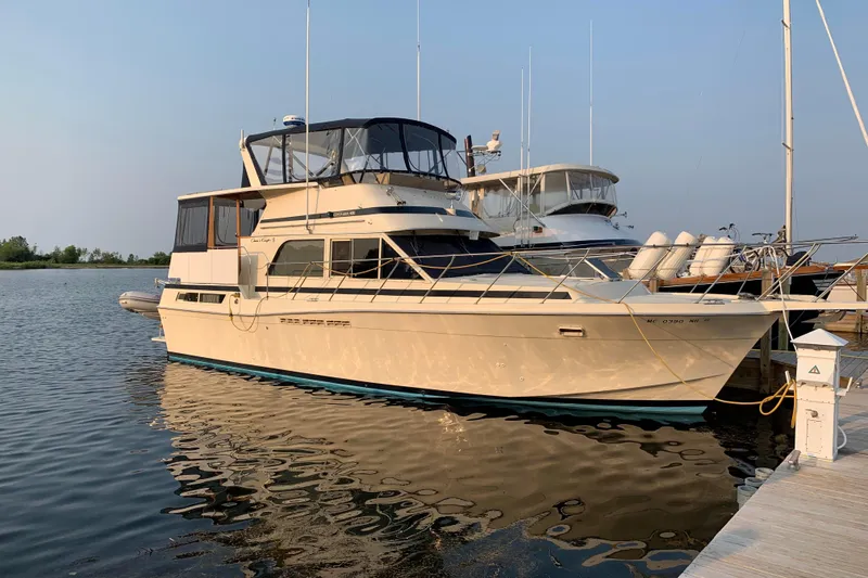 Slide: The Image of 1987 Chris-Craft 427 Catalina yacht docked at marina, reflecting on calm water. - 0