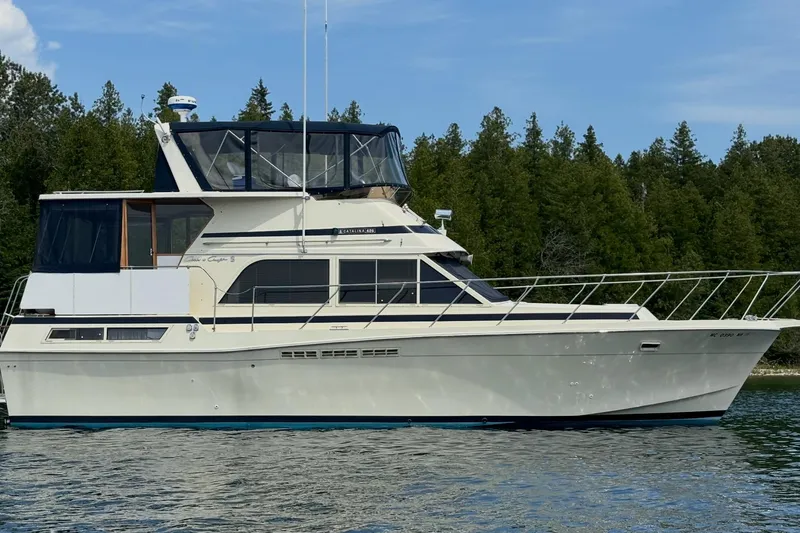 Slide: The Image of 1987 Chris-Craft 427 Catalina yacht on calm water with forested background. - 1
