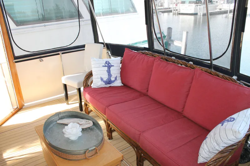 Slide: The Image of Interior of 1987 Chris-Craft 427 Catalina with red sofa, nautical decor, and marina view. - 13