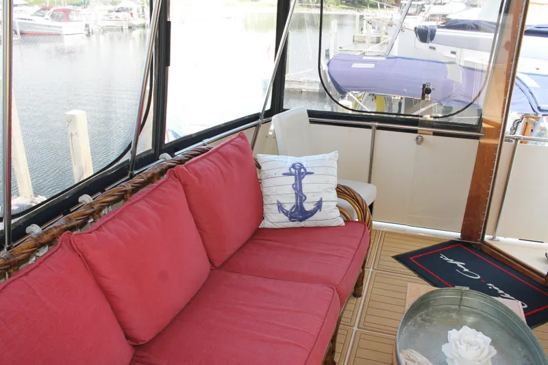 Slide: The Image of 1987 Chris-Craft 427 Catalina interior with red sofa, anchor pillow, and marina view. - 14