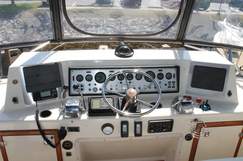 Slide: The Image of 1987 Chris-Craft 427 Catalina helm with steering wheel, gauges, and navigation equipment. - 22