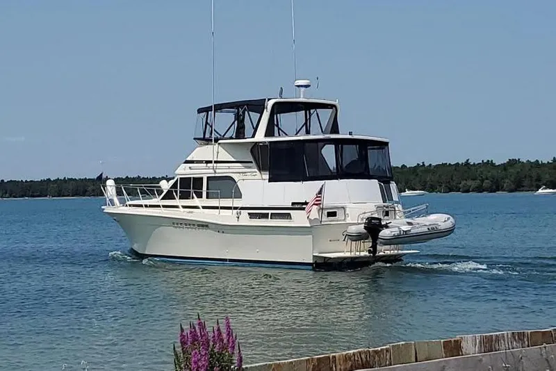 Slide: The Image of 1987 Chris-Craft 427 Catalina yacht cruising on a serene lake with clear skies. - 3
