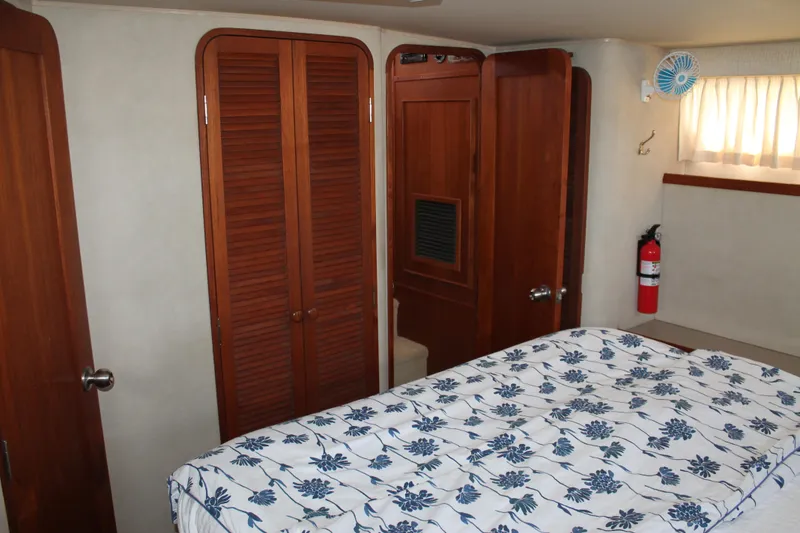 Slide: The Image of Interior cabin of 1987 Chris-Craft 427 Catalina with floral bedding and wooden closets. - 43
