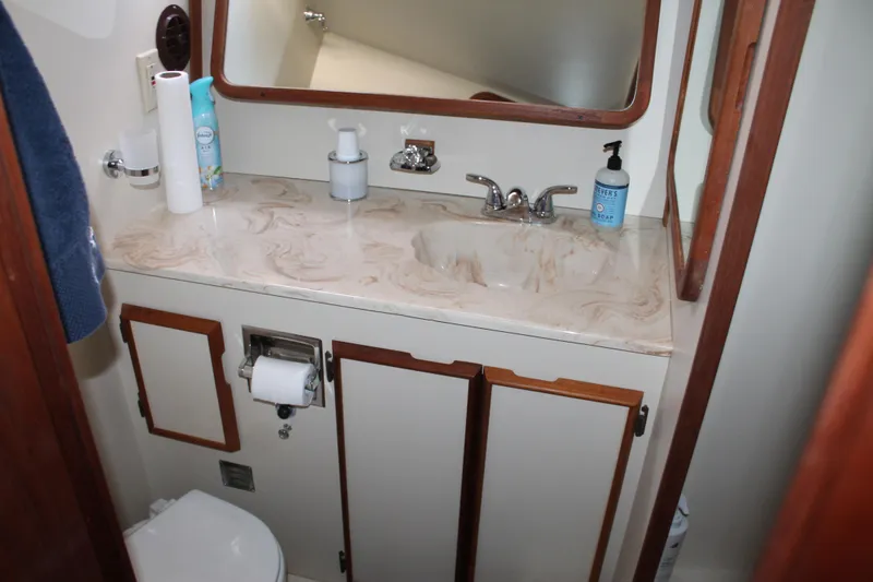 Slide: The Image of 1987 Chris-Craft 427 Catalina bathroom with marble countertop, sink, and wooden cabinetry. - 45