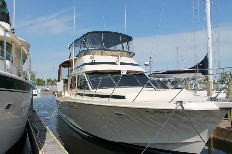 Slide: The Image of 1987 Chris-Craft 427 Catalina yacht docked at a marina under a clear blue sky. - 7