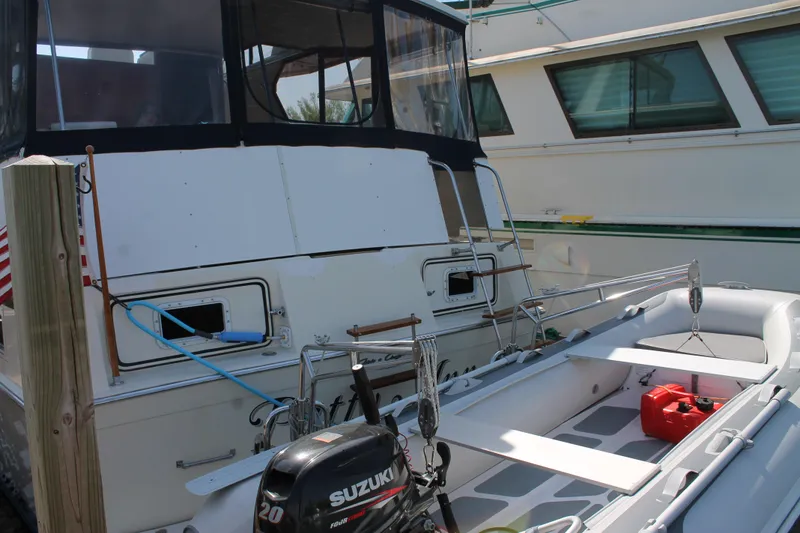 Slide: The Image of 1987 Chris-Craft 427 Catalina yacht with dinghy and Suzuki outboard motor at dock. - 9
