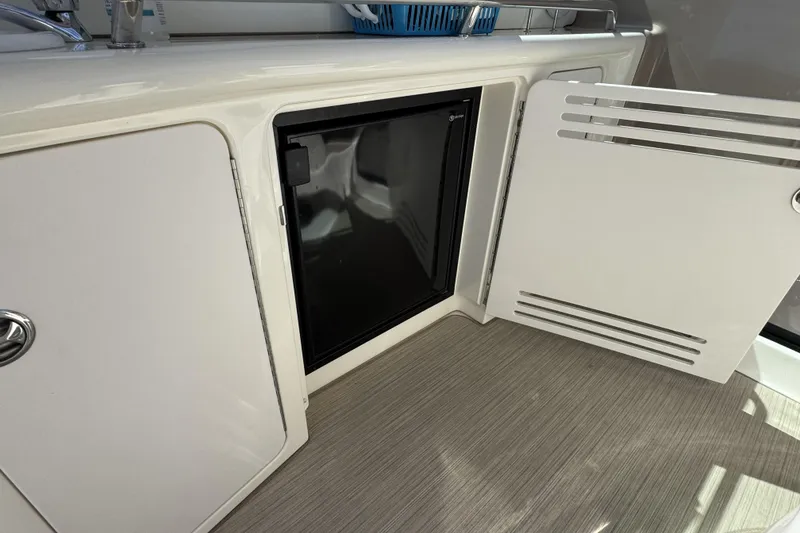 Slide: The Image of 2002 Sea Ray 360 Sundancer interior with open cabinet and mini fridge. - 12