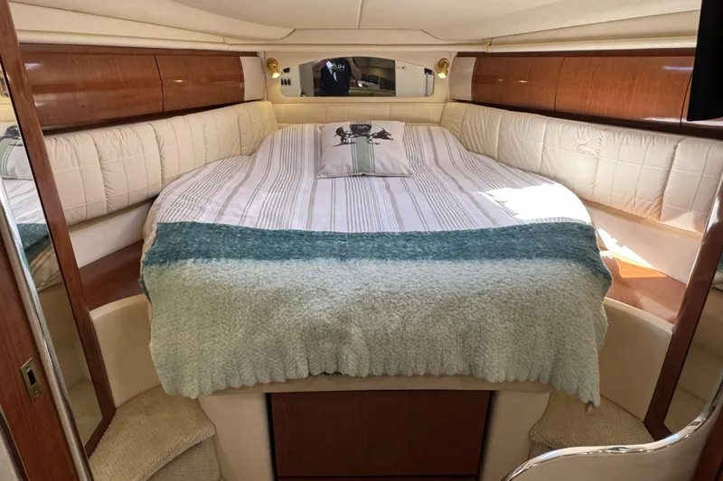 Slide: The Image of Luxurious cabin interior of 2002 Sea Ray 360 Sundancer with cozy bedding and wood accents. - 19