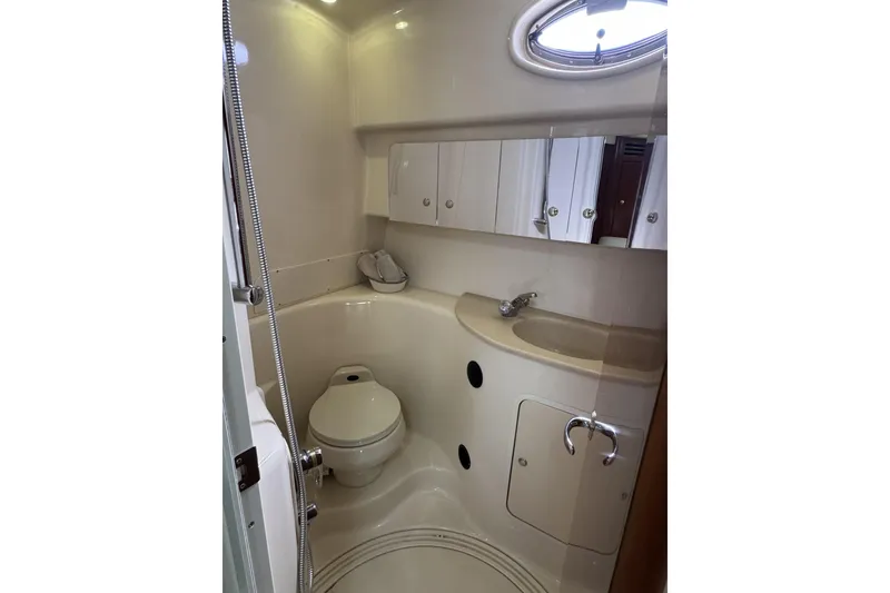 Slide: The Image of Compact bathroom in a 2002 Sea Ray 360 Sundancer yacht, featuring a toilet and sink. - 26