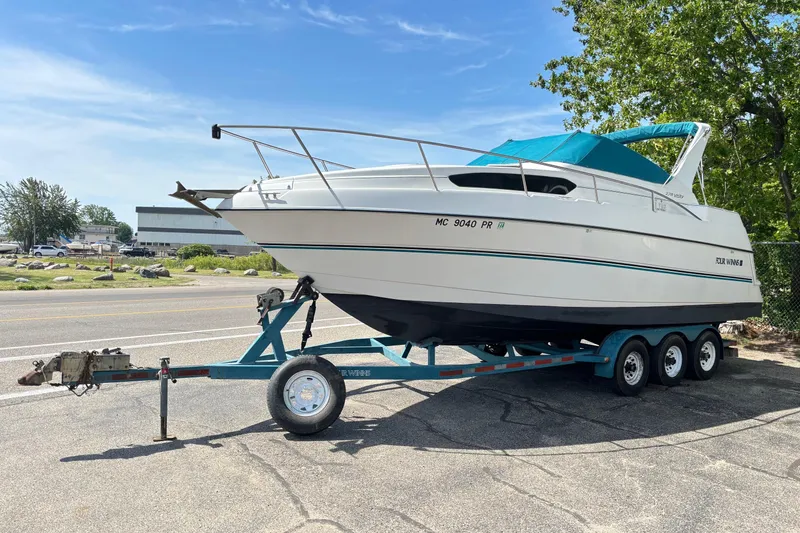 The Image of 1994 Four Winns 278 Vista boat on a trailer, parked outdoors under a clear sky. - 0