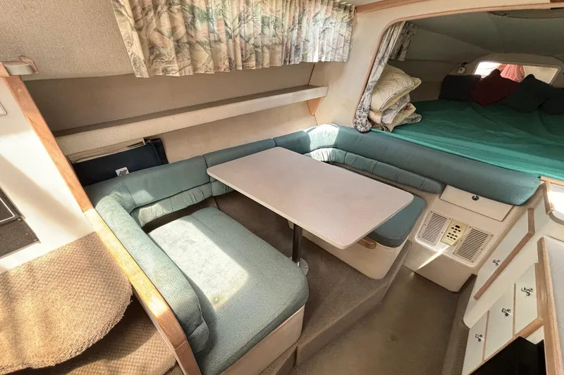 Slide: The Image of Interior of 1994 Four Winns 278 Vista boat with cozy seating and table. - 17