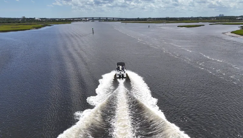 Slide: The Image of A 2027 Sea Ray SDX 290 Outboard cruising on a wide river with a bridge in the background. - 23