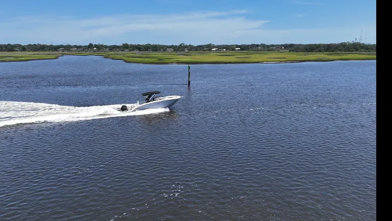 Slide: The Image of A 2027 Sea Ray SDX 290 Outboard speeds across calm waters. - 25