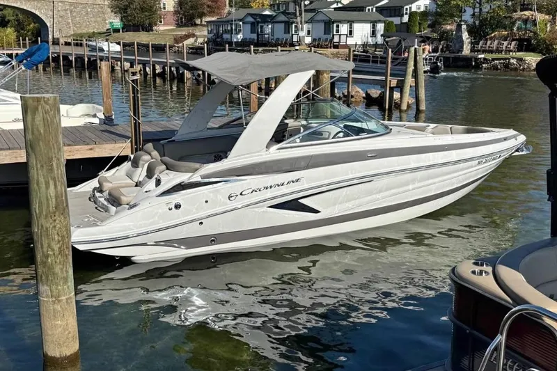 The Image of 2022 Crownline 265 SS boat docked in a scenic marina setting. - 1