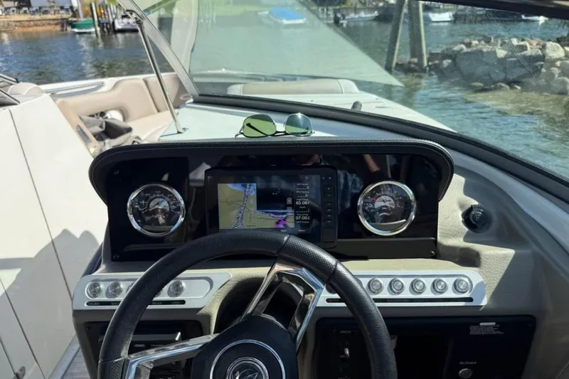 Slide: The Image of 2022 Crownline 265 SS boat dashboard with steering wheel and navigation display. - 6