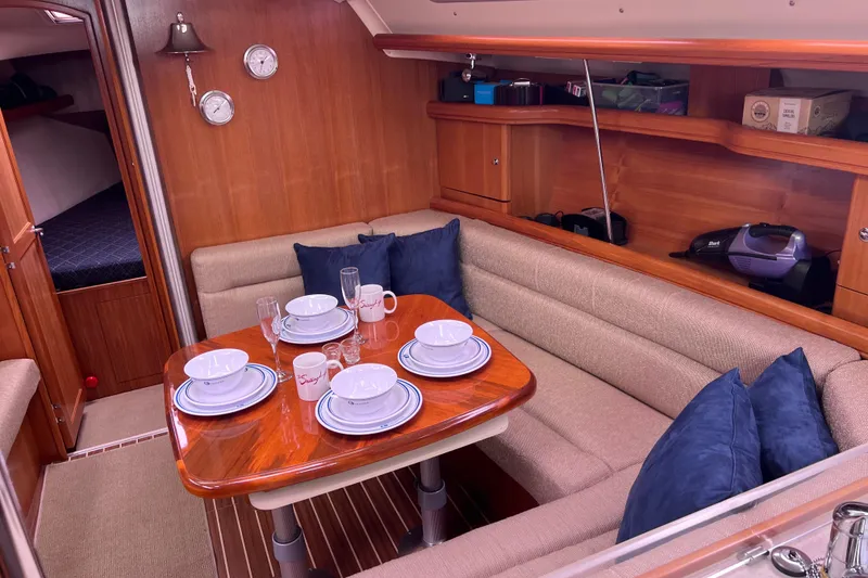 Slide: The Image of Interior of a 2006 Hunter 38 yacht with dining table and dishware. - 10