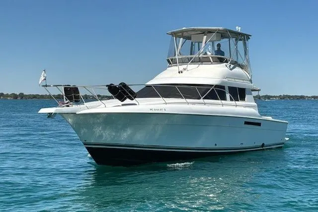 The Image of 2000 Silverton 41 Convertible yacht cruising on clear blue water. - 0