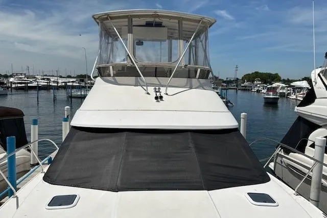 Slide: The Image of 2000 Silverton 41 Convertible yacht docked at marina under clear sky. - 1