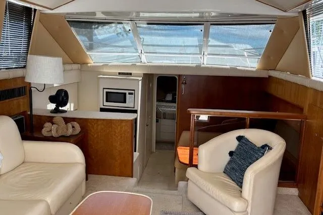 Slide: The Image of Interior of 2000 Silverton 41 Convertible yacht with seating, kitchenette, and natural light. - 12