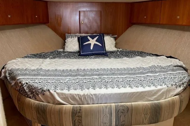 Slide: The Image of Luxurious bedroom interior of 2000 Silverton 41 Convertible yacht with starfish-themed decor. - 16